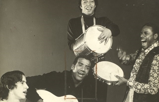 Jorge_Ben_e_o_Trio_Mocotó_no_Teatro_da_Lagoa,_1971 são quatro homens cantando em um palco